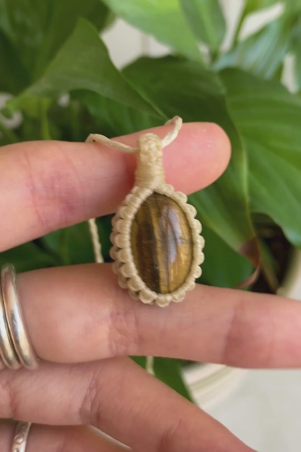 Video of a handmade Tiger’s Eye macrame necklace, showcasing how the gemstone shines with its captivating golden-brown hues and macrame details.