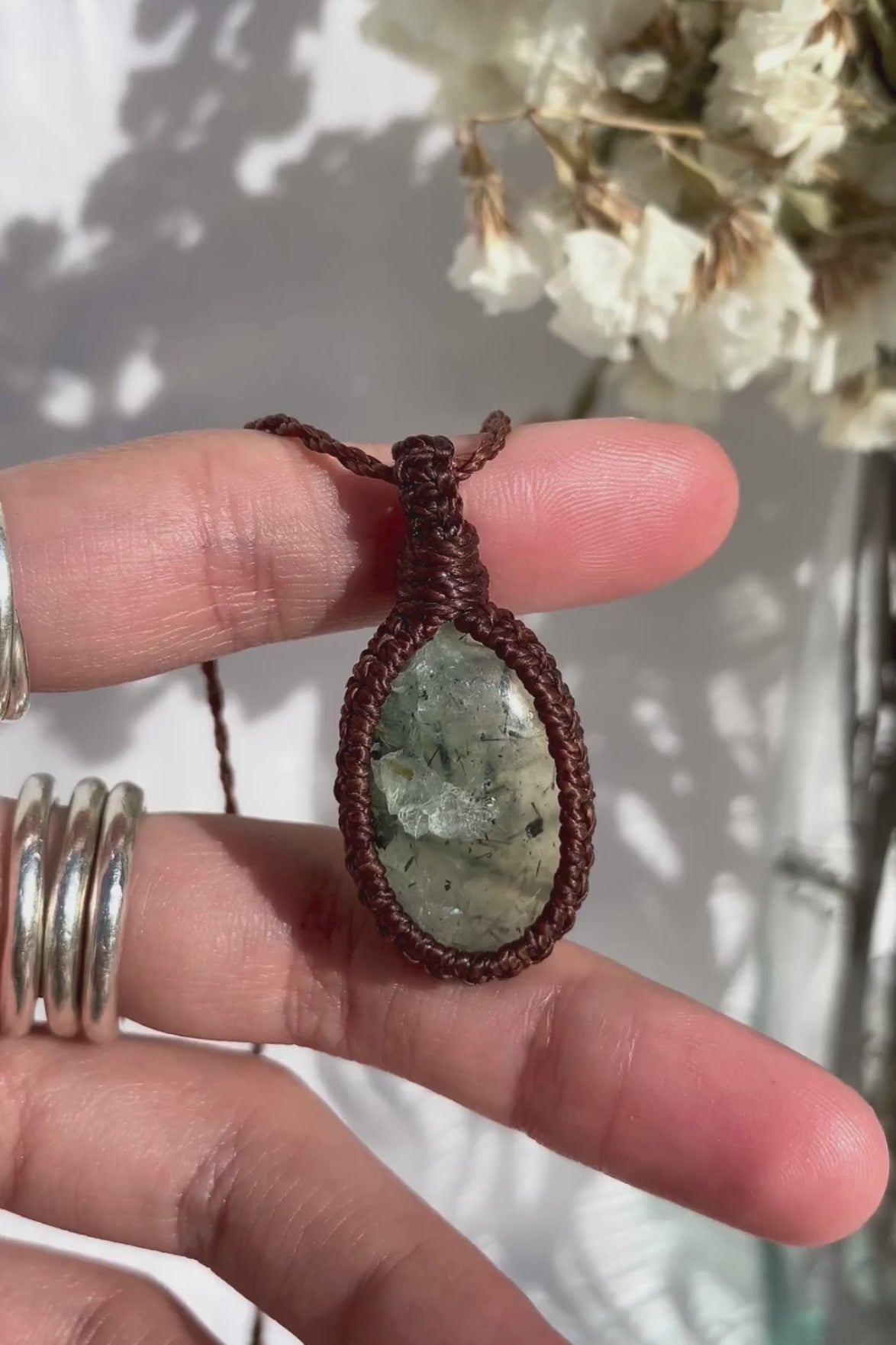 Video of a handmade Prehnite macrame necklace, capturing the soft green gemstone’s natural glow and the intricate macrame knotting.