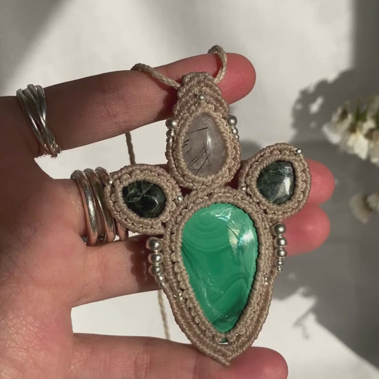 Close-up video of a handmade gemstone necklace, capturing the natural shine and intricate details of Malachite, Seraphinite and Tourmaline, Quartz. The unique design and polished gemstones reflect the light beautifully, highlighting the craftsmanship and one-of-a-kind artistry.