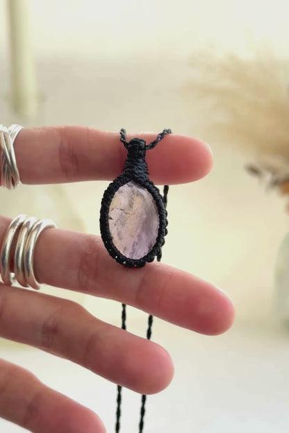 Video showcasing the harmonious blend of soft purple Amethyst hues and the mysterious golden glow of Citrineo gemstones, held in hand with its black macrame necklace.