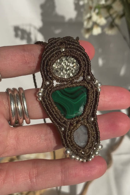 Close-up video of a handmade gemstone necklace, capturing the natural shine and intricate details of Raw Pyrite, Moonstone and Malachite. The unique design and polished gemstones reflect the light beautifully, highlighting the craftsmanship and one-of-a-kind artistry.