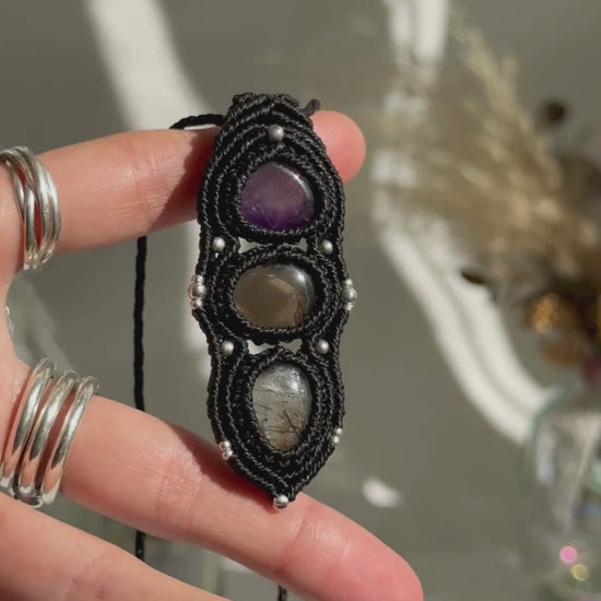 Video of a handmade Amethyst, Smoky Quartz and Tourmaline Quartz macrame necklace. Displaying natural gemstone colors, light reflections, and fine macrame details.