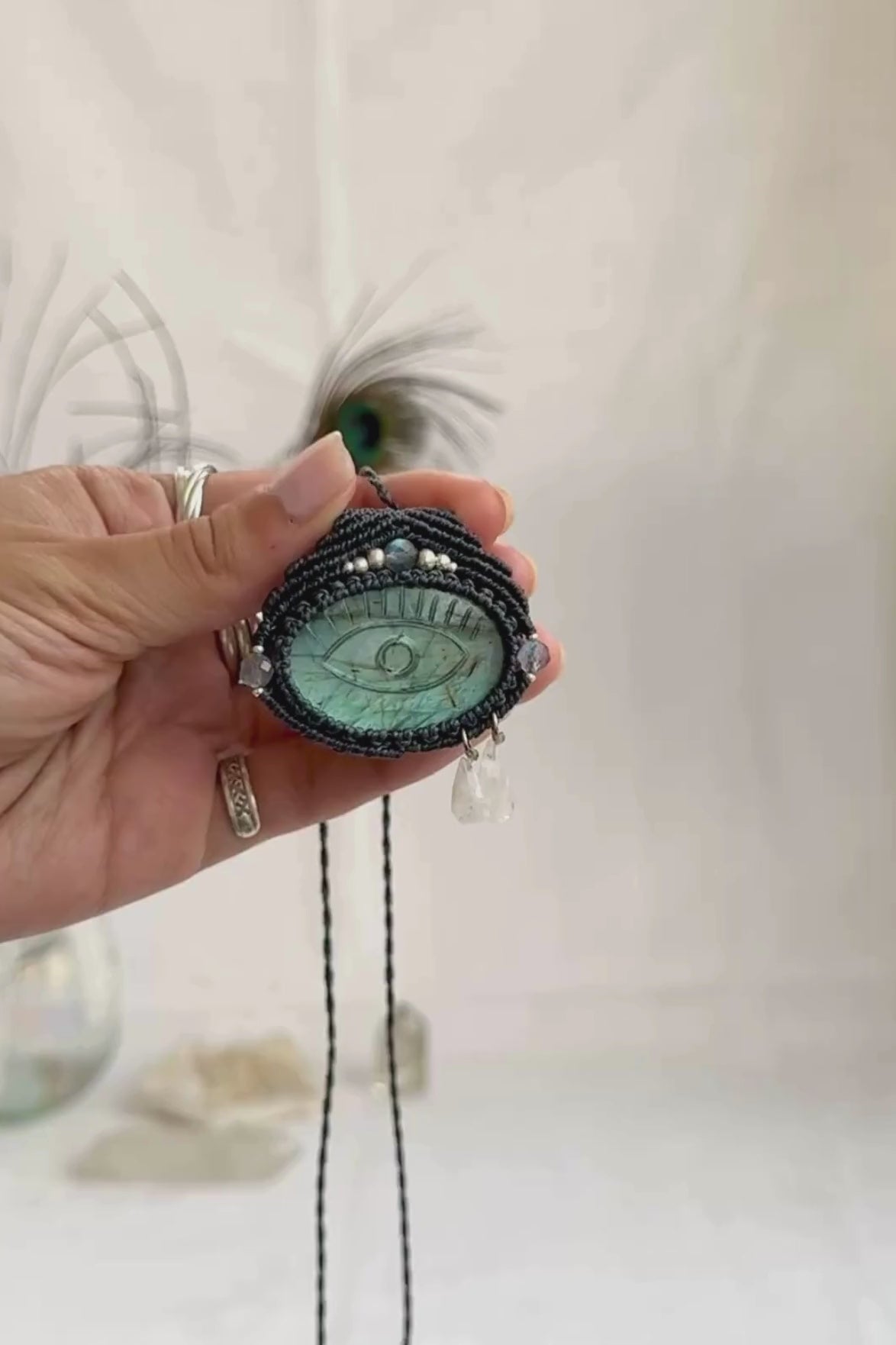 Video of Labradorite protective eye necklace, showing shifting blue hues and natural labradorescence of the gemstone, accented with Moonstone dropping tears.