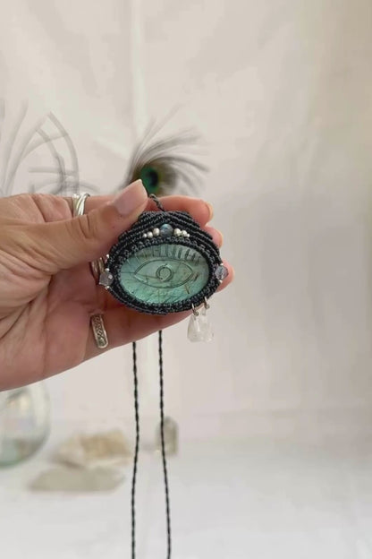 Video of Labradorite protective eye necklace, showing shifting blue hues and natural labradorescence of the gemstone, accented with Moonstone dropping tears.