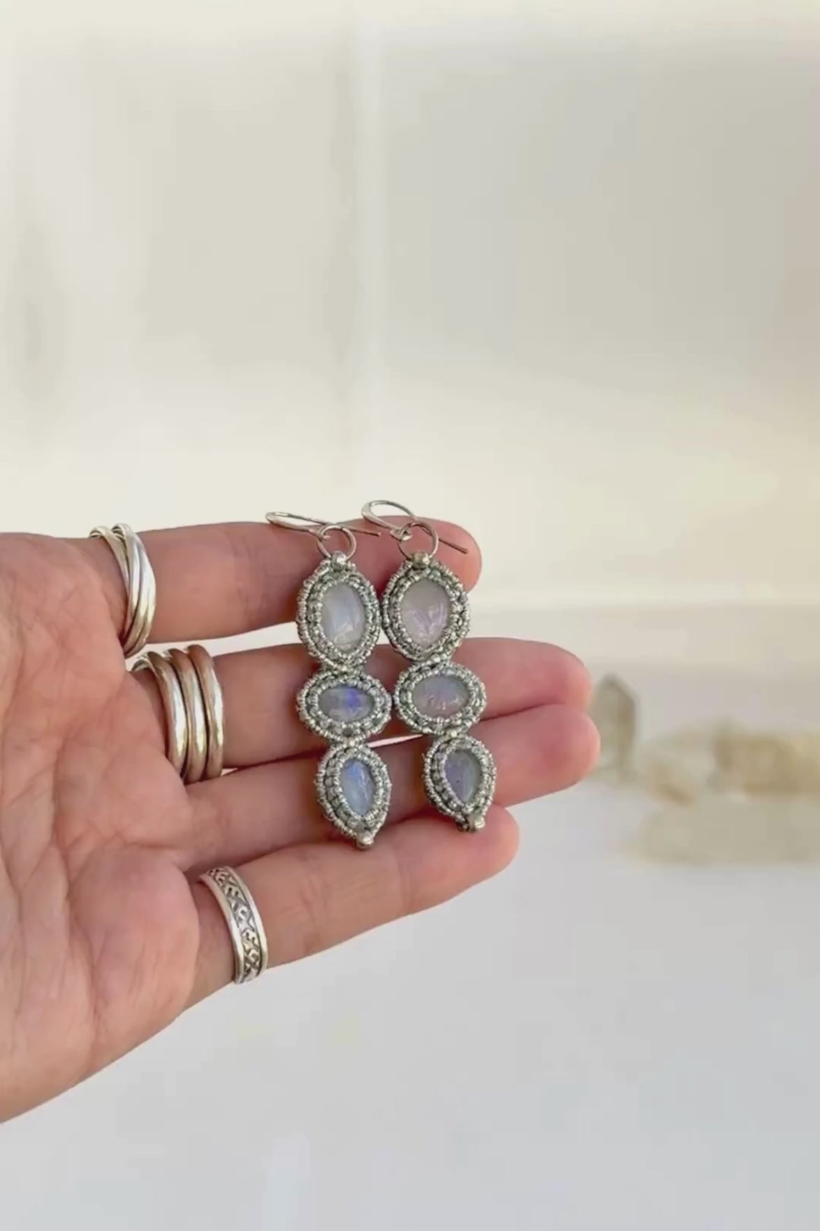 Video showcasing the handmade macrame earring design with three Moonstone gemstones each. Showing the glow of the gemstones, the intricate macrame work and the unique design.