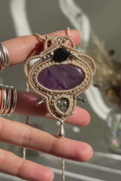 Video of a handmade Amethyst and Raw Druzy Pyrite macrame necklace. Displaying natural gemstone colors, light reflections, and fine macrame details.