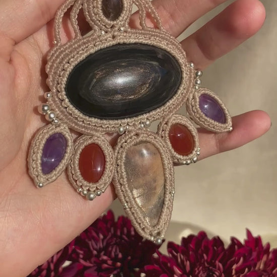 Video showcasing the handmade macrame necklace with obsidian, black moonstone, smoky quartz, carnelian, and amethyst, highlighting the gemstones’ shine and vibrant colors in movement.