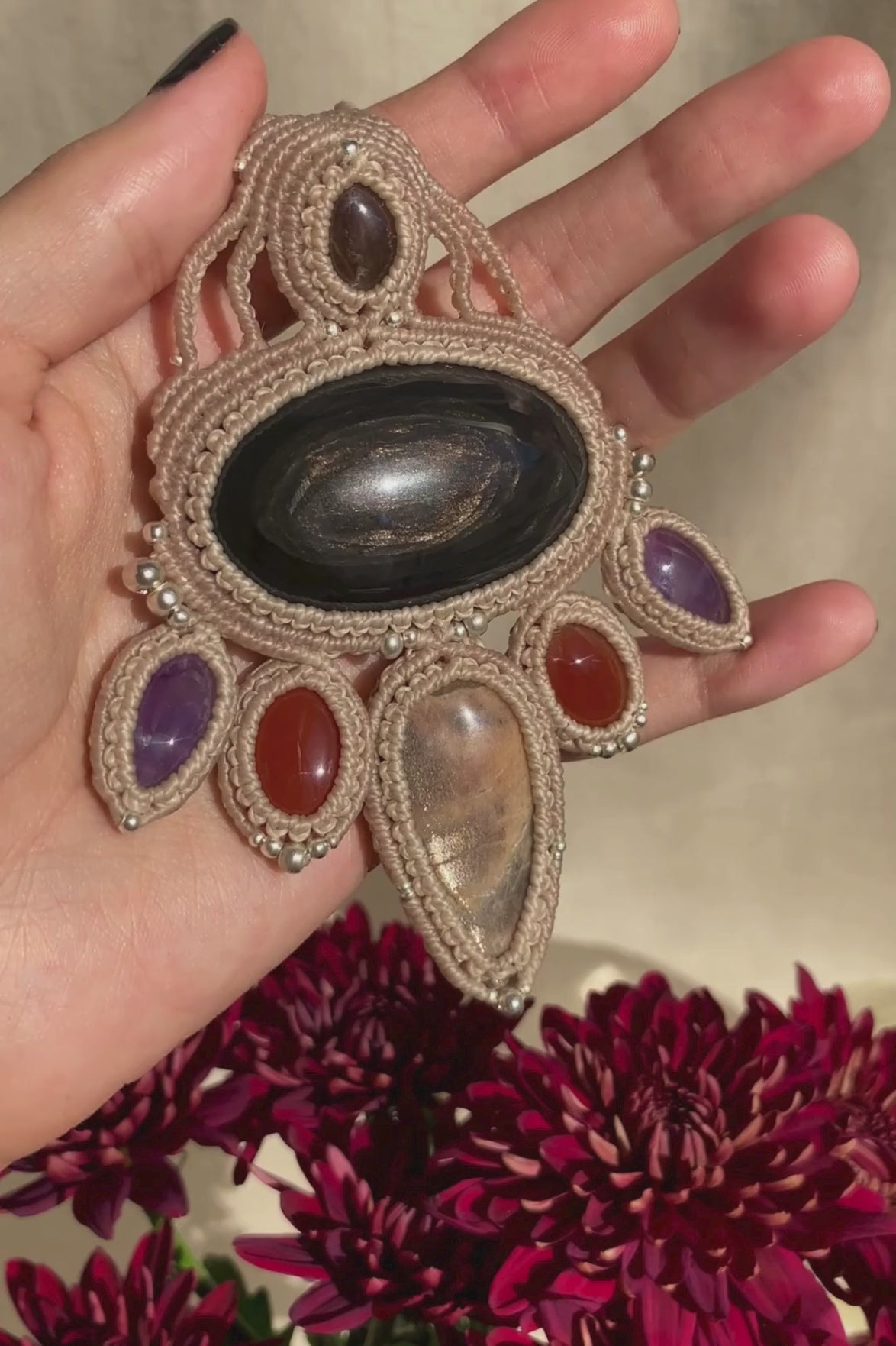 Video showcasing the handmade macrame necklace with obsidian, black moonstone, smoky quartz, carnelian, and amethyst, highlighting the gemstones’ shine and vibrant colors in movement.