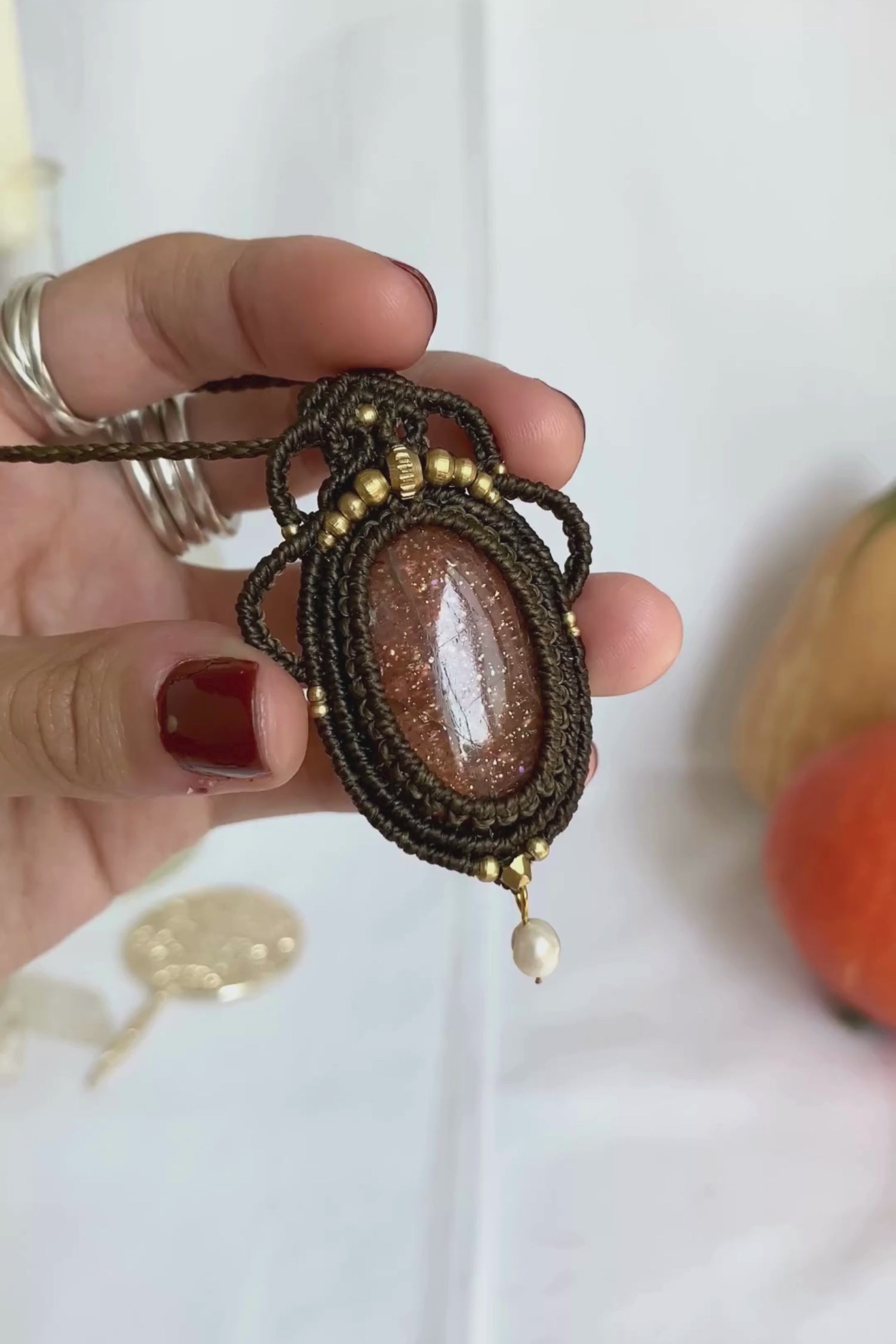 Close-up video of a handmade gemstone necklace, capturing the natural shine and intricate details of Sunstone and Fresh Water Pearl. The unique design and polished gemstones reflect the light beautifully, highlighting the craftsmanship and one-of-a-kind artistry.