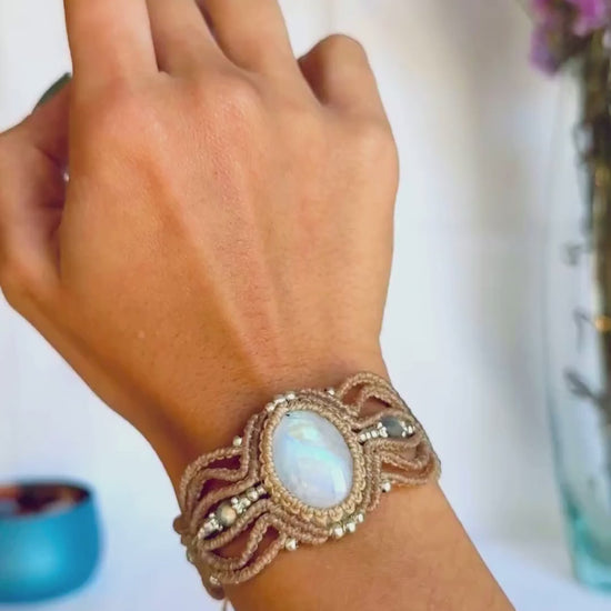 Detailed view of the macrame cuff bracelet, showing the iridescent flashes of the Rainbow Moonstone and faceted Labradorite beads.