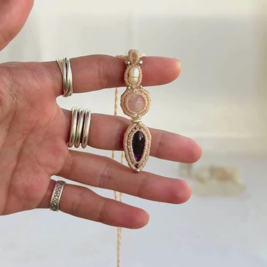 Video of a handmade Freshwater Pearl, Rose Quartz and Amethyst macrame necklace. Displaying natural gemstone colors, light reflections, and fine macrame details.