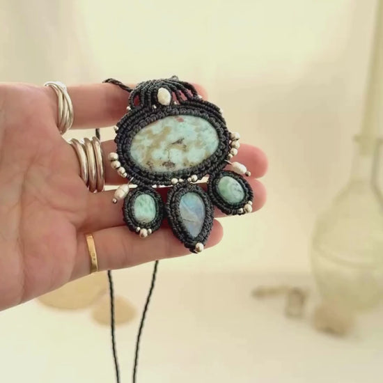 Video showing the movement and natural shine of a Larimar and Moonstone macramé necklace with pearl and silver accents