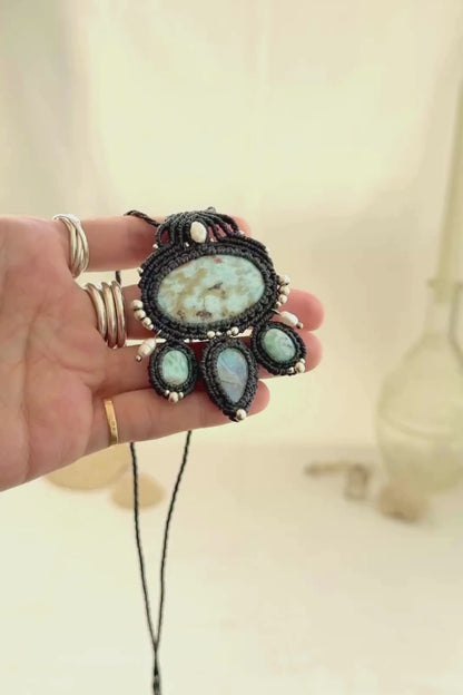 Video showing the movement and natural shine of a Larimar and Moonstone macramé necklace with pearl and silver accents