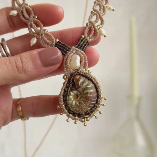 Iridescent ammonite fossil necklace showcasing natural color reflections and pearl details