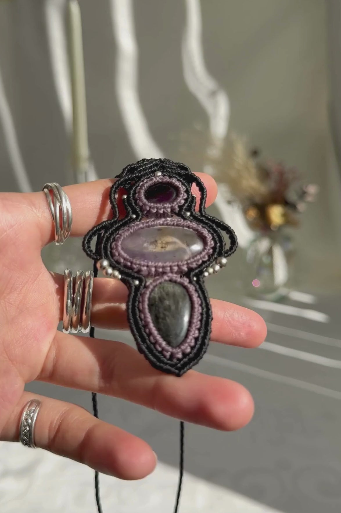 Video of a handmade Amethyst, Ametrine and Silver Sheen Obsidian macrame necklace. Displaying natural gemstone colors, light reflections, and fine macrame details.