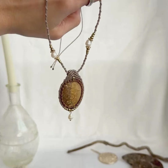 Video showing fossil coral pendant necklace with freshwater pearl drop, pearls along macramé cord, and detailed craftsmanship