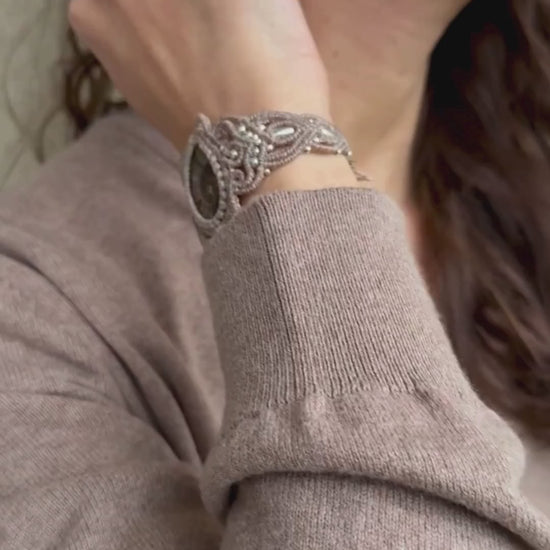 Ammonite cuff bracelet in motion on wrist, showing sculptural form, natural fossil detail, and adjustable fit