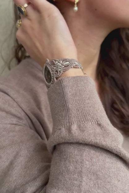 Ammonite cuff bracelet in motion on wrist, showing sculptural form, natural fossil detail, and adjustable fit