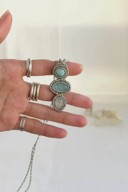 Video of a handmade Larimar, Aquamarine and Moonstone macrame necklace. Displaying natural gemstone colors, light reflections, and fine macrame details.