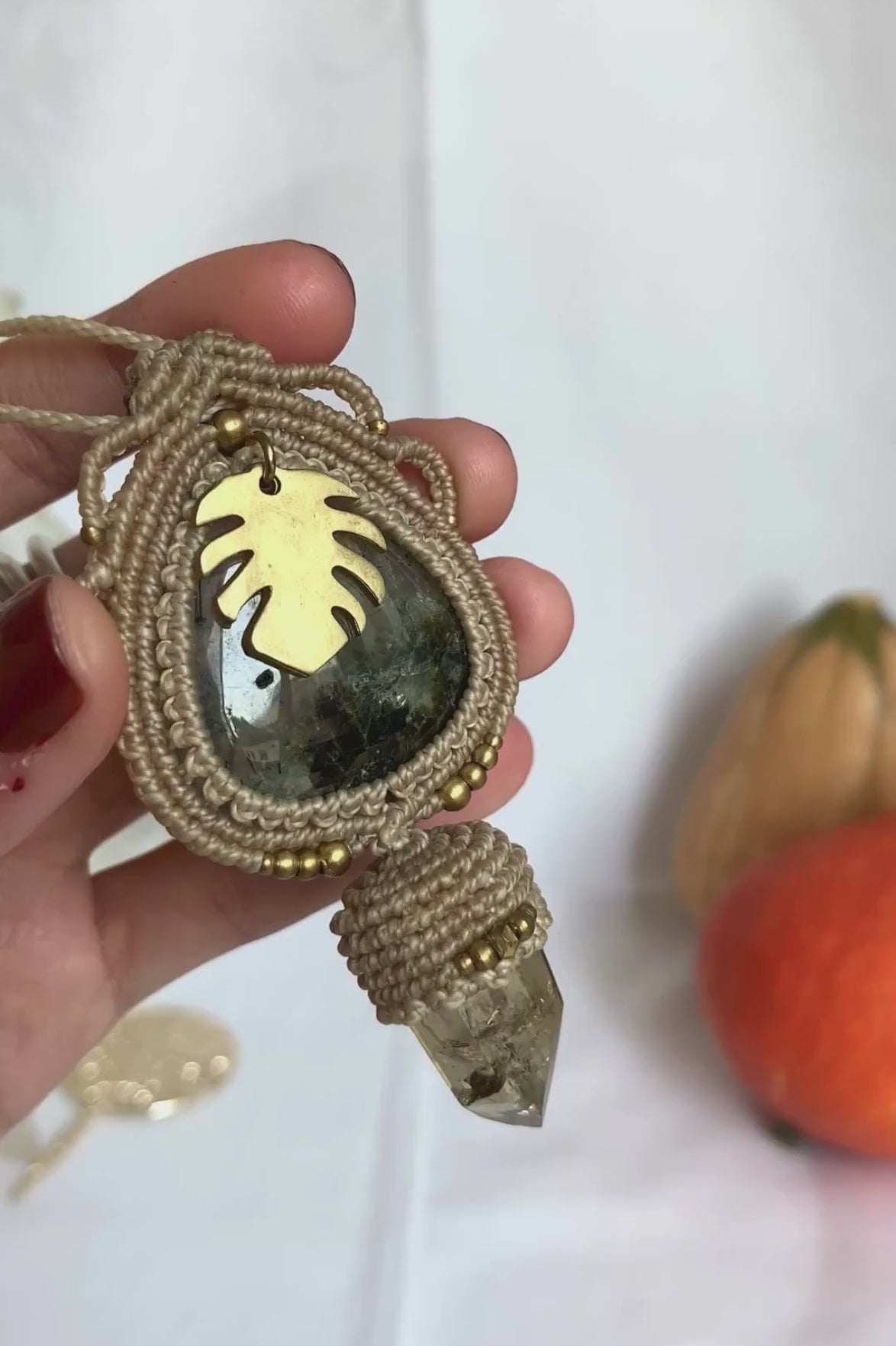 Close-up video of a handmade gemstone necklace, capturing the natural shine and intricate details of Prehnite and Raw Smoky Quartz Point. The unique design and polished gemstones reflect the light beautifully, highlighting the craftsmanship and one-of-a-kind artistry.