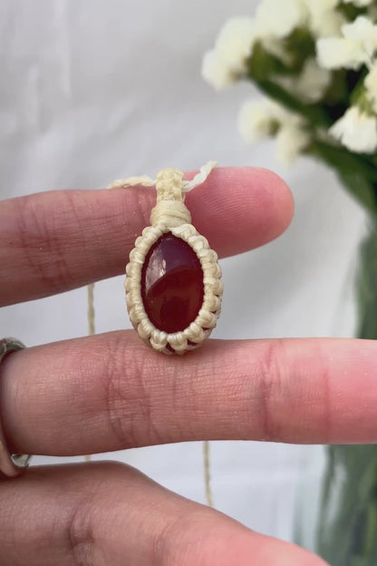 Video of a handmade Carnelian macrame necklace, capturing the gemstone’s fiery red glow and the intricate macrame knotting in detail.