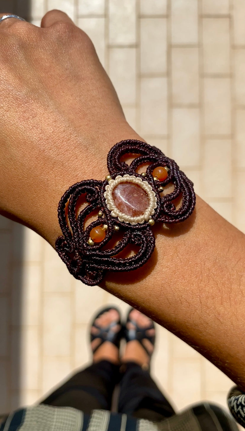 Close-up video of the handmade bracelet, capturing the shimmer of the Sunstone and the brilliance of the carnelian accents, highlighting the unique craftsmanship and quality of the design.